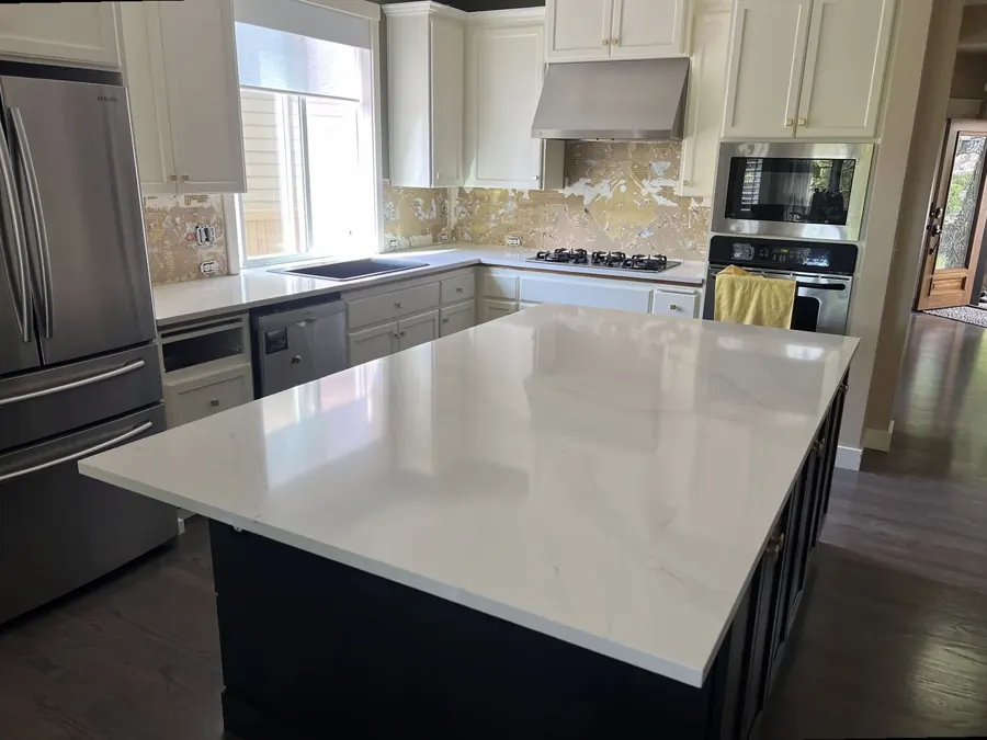 Quartz island with a dark base in a finished kitchen