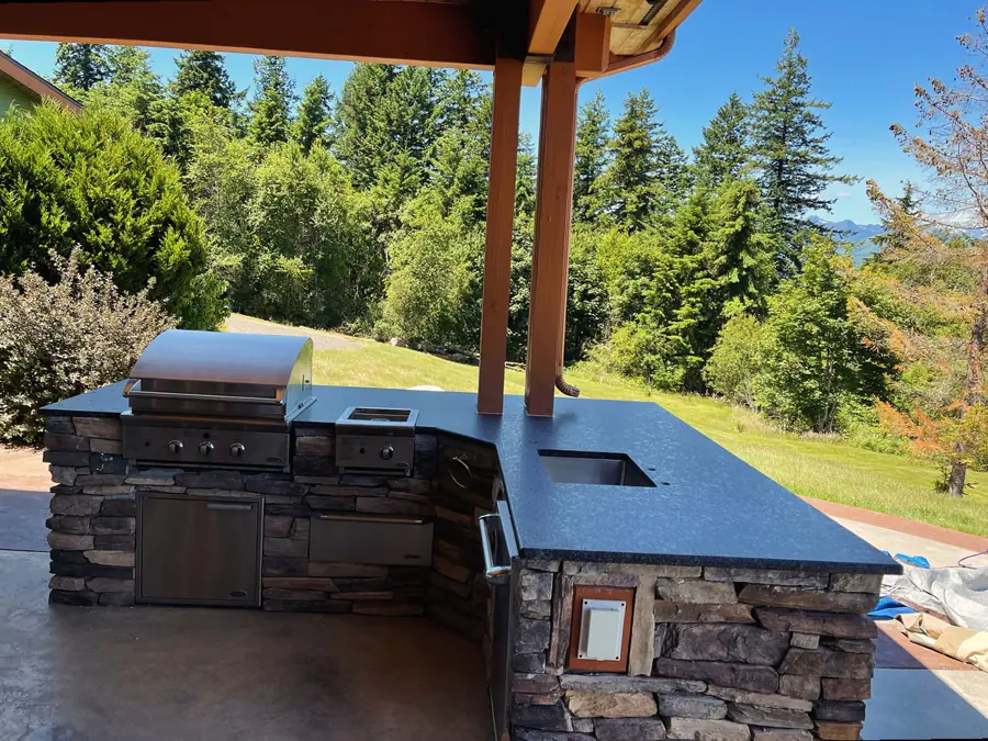 Outdoor kitchen counter in dark granite with a forest view